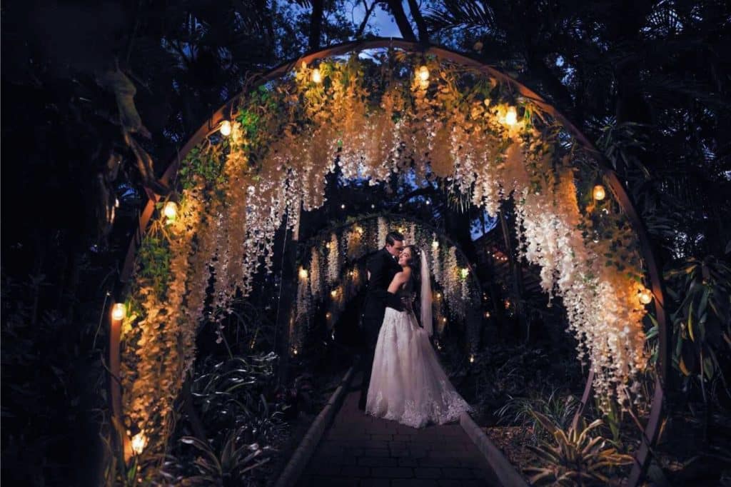 mariage nuit noire arche arc de cercle avec fleurs mariées photo bisou