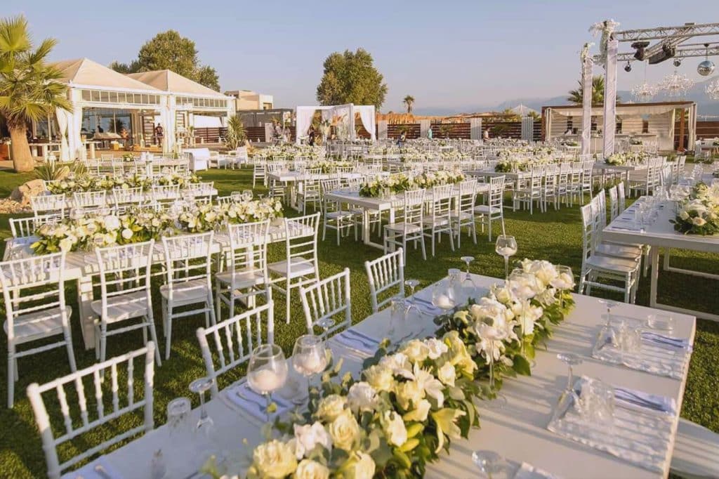mariage en extérieur soleil jardin tables et chaises blanches chemin fleurs