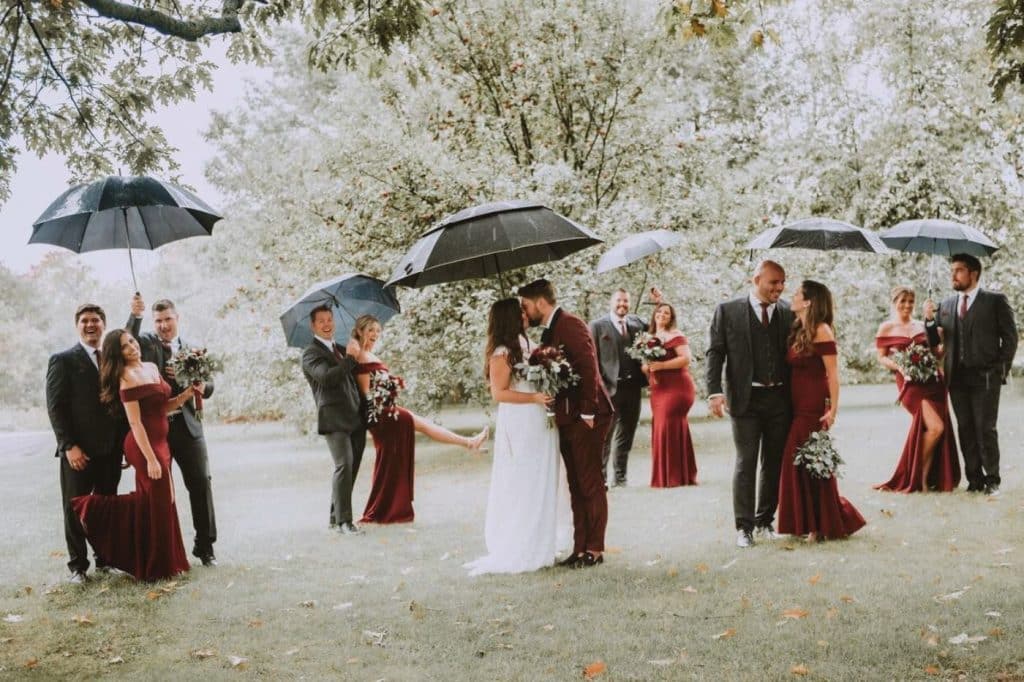 photo de groupe mariage sous la pluie témoins et demoiselles d'honneur parapluie iconique