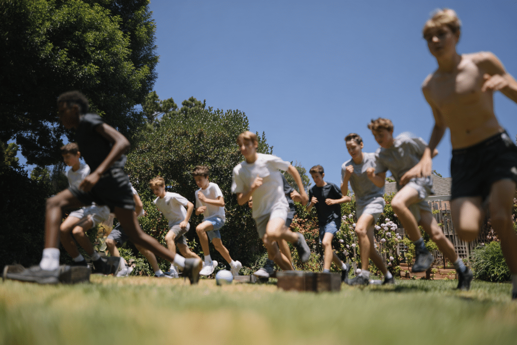 Défis sport chronométrés pour anniversaire 14 ans avec groupe de garçons faisant des challenges sportifs dans un jardin