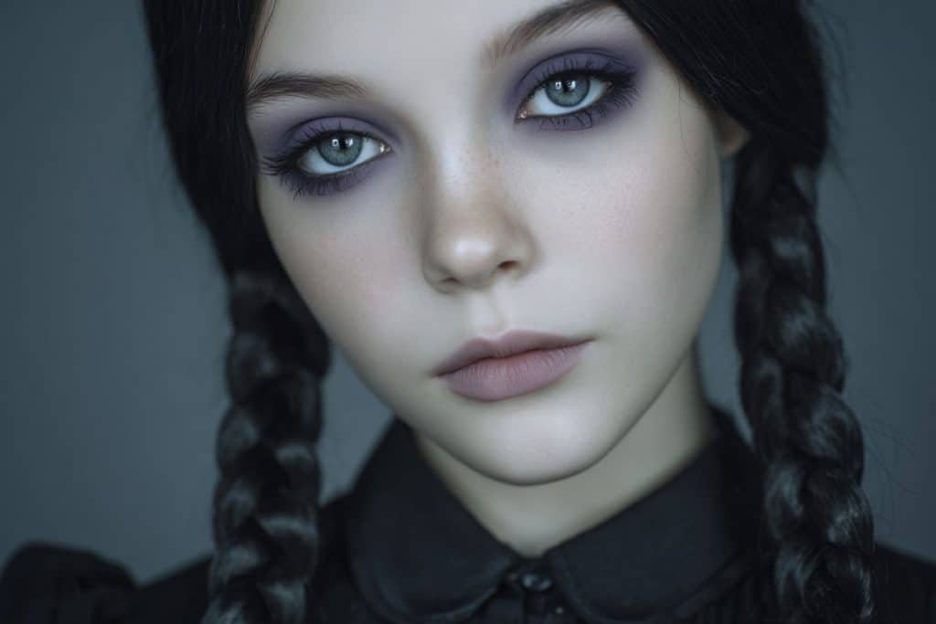 Maquillage Mercredi Addams pour enfant avec teint clair et ombres violettes dans un style gothique doux