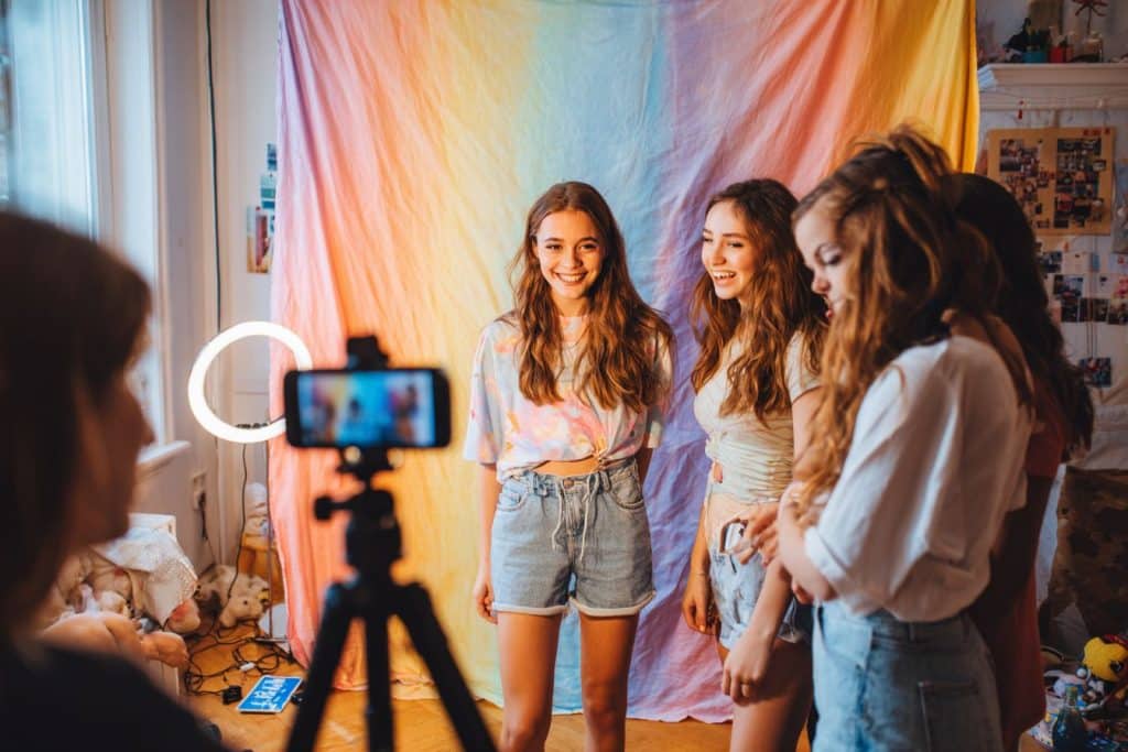 Groupe de filles de 14 ans faisant un mini shoot photo avec fond coloré et éclairage pour anniversaire