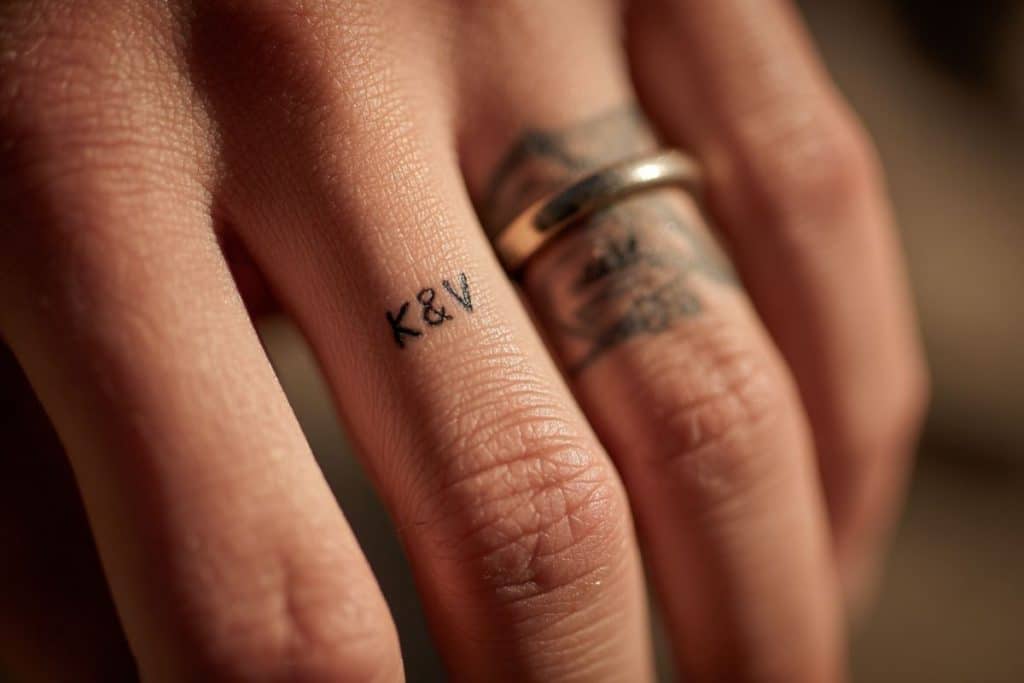 Tatouage alliance avec initiales et date gravées sur doigt K&V anneau