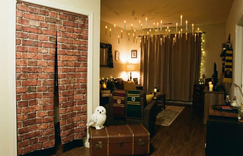 Décoration immersive pour un anniversaire Harry Potter dans un appartement, avec bougies flottantes au plafond et entrée Voie 9 ¾