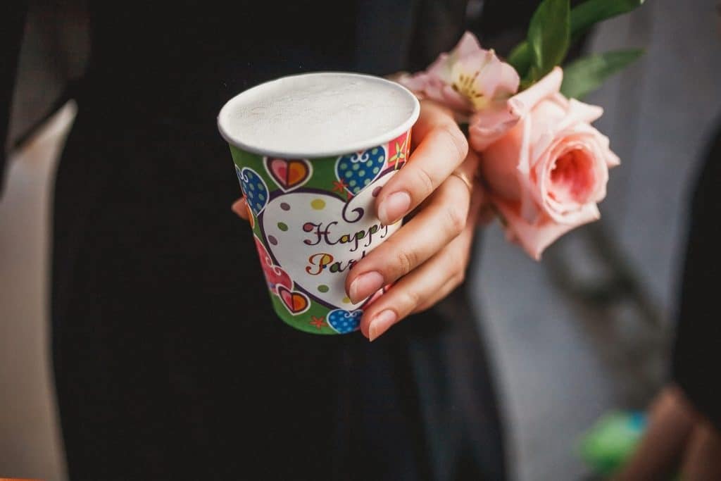 gobelet personnalisé couleur anniversaire dans la main d'une femme gros plan zoom